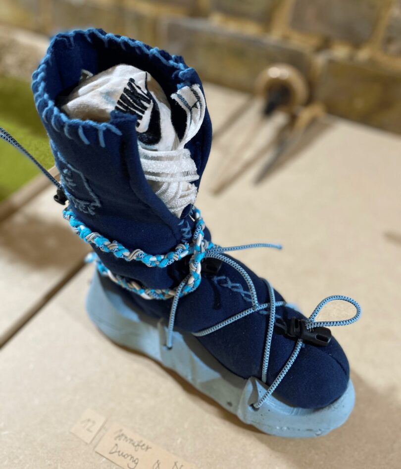 A blue boot on a foam sole in wrapped in cord