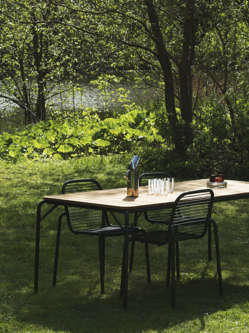 dark green and light wood outdoor dining table and matching chairs outside