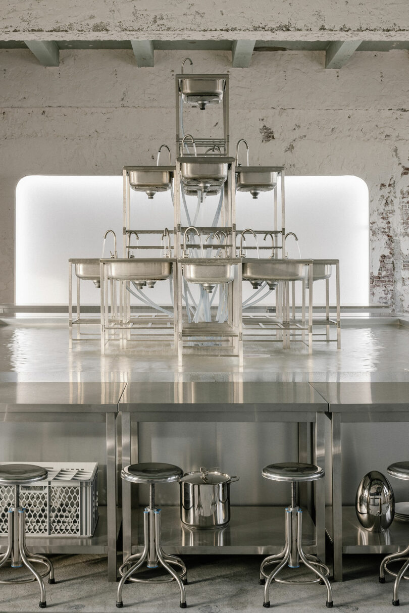factory setting of exhibition showcasing restaurant dish sinks with surrounding chairs