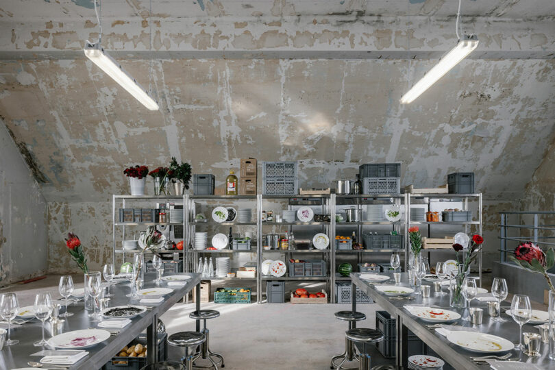 exhibition setting of popup restaurant with industrial look and shelves of kitchen tools