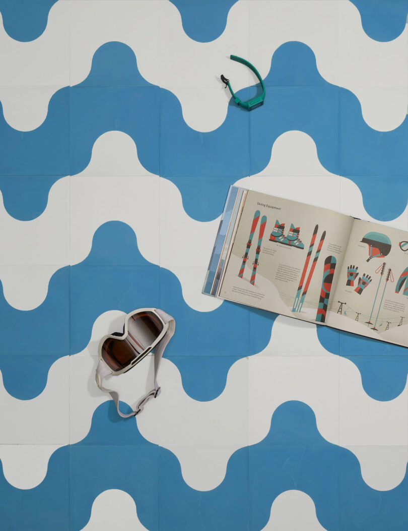 book and goggles on top of blue and white tiles