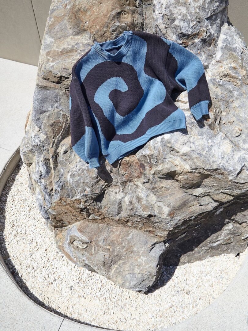 black and blue sweater on a rock