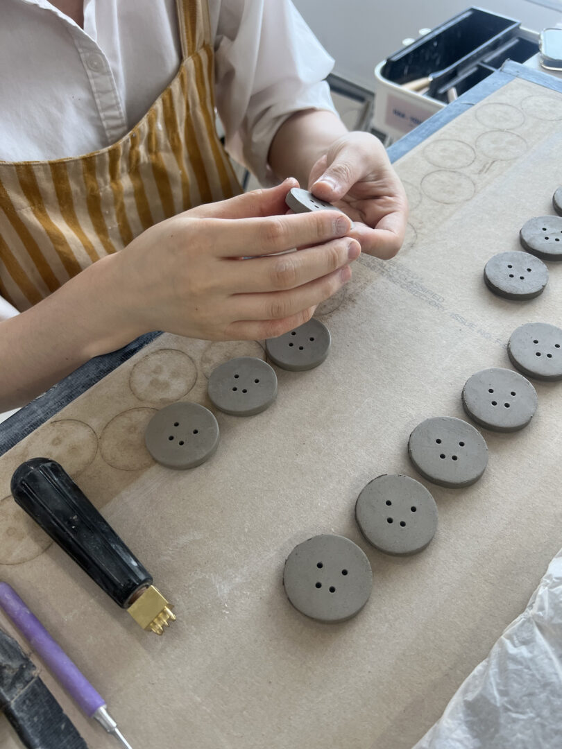 hands making ceramic buttons
