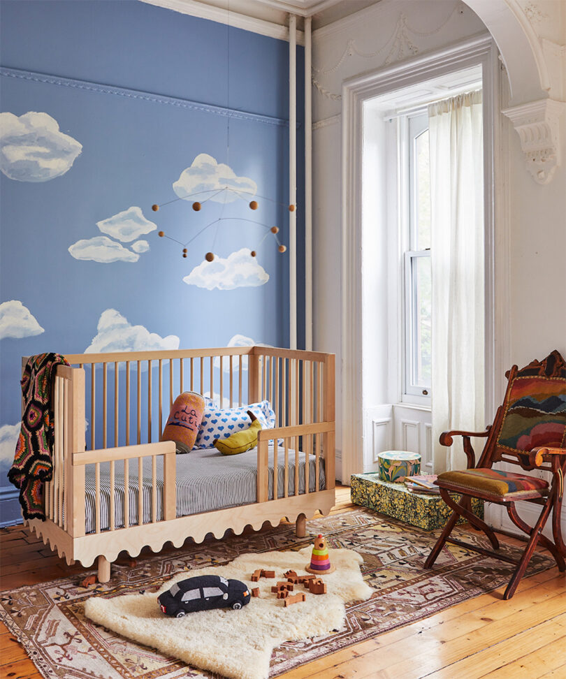 toddler conversion kit on wavy birch crib in cloud wallpaper room