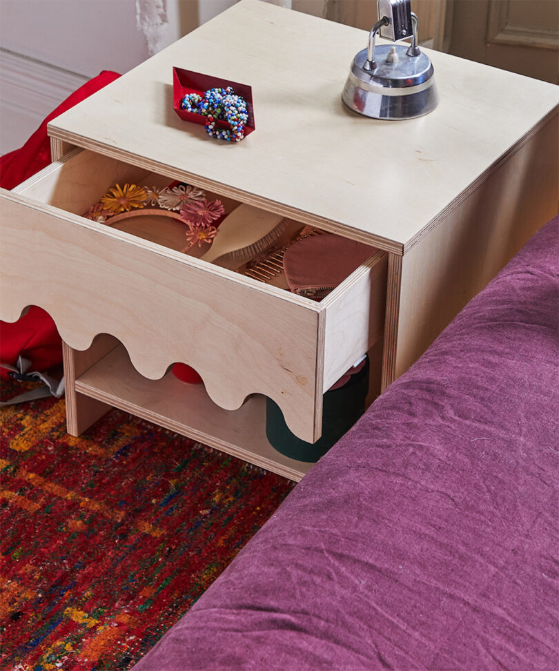 open drawer on wavy wooden nightstand