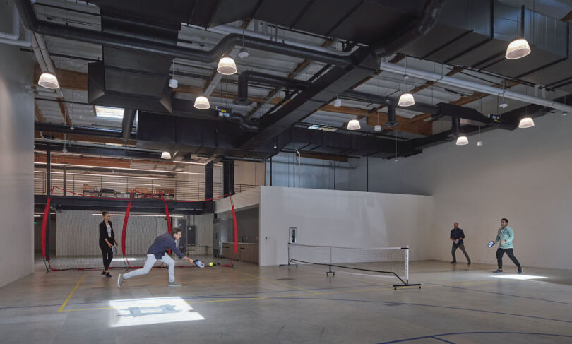 employees playing pickleball in warehouse office