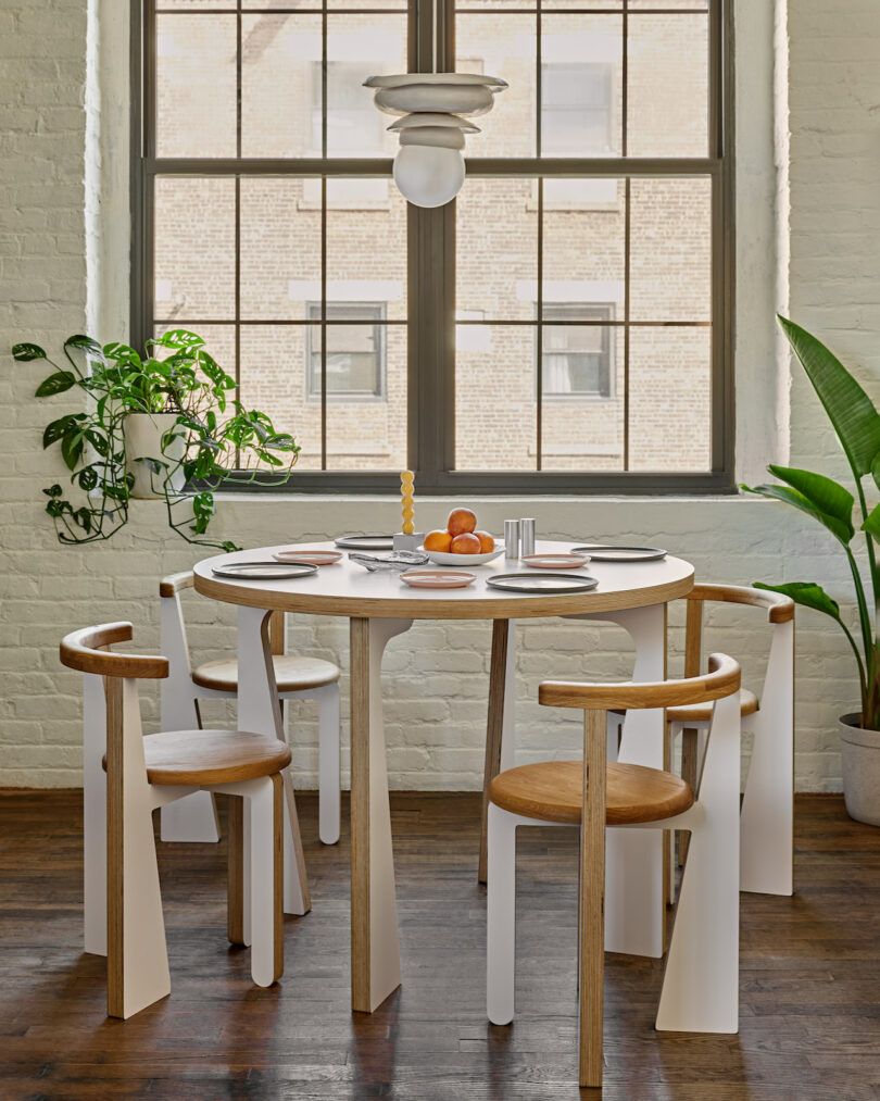 white dining chairs and dining table under a pendant lamp