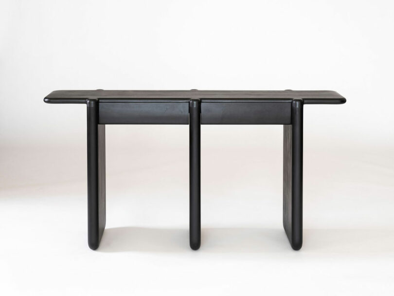 Black console table with three legs.