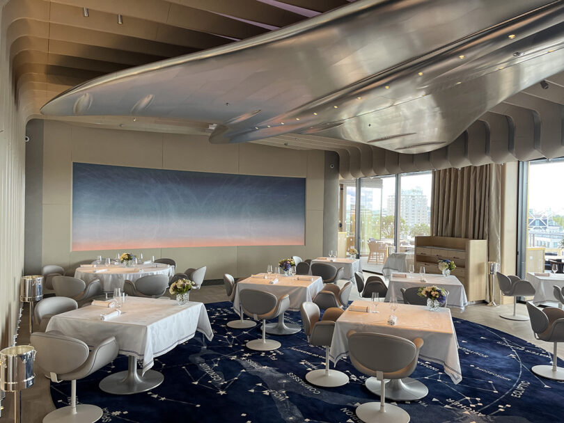 Dining room of the Brooklands restaurant with large polished aluminum sculpture of the Concorde jet plane secured above across the ceiling.