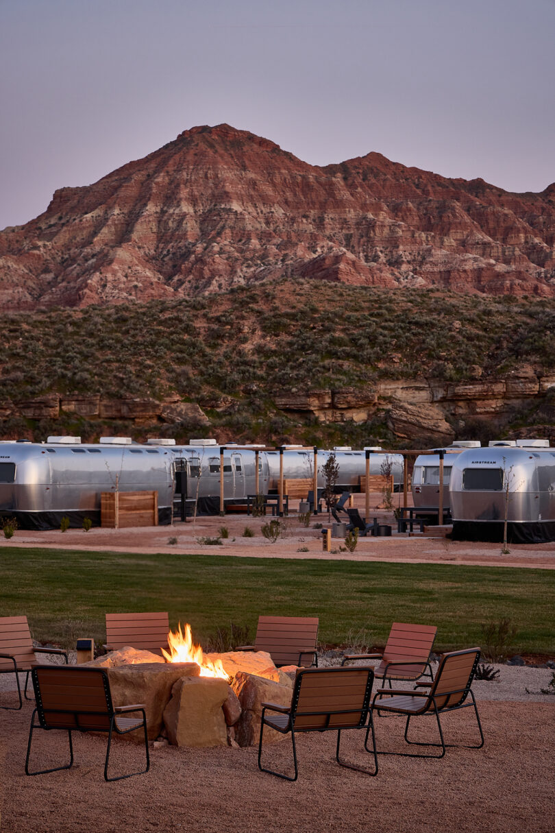 row of silver Airstream trailers in the desert with a mountainous backdrop