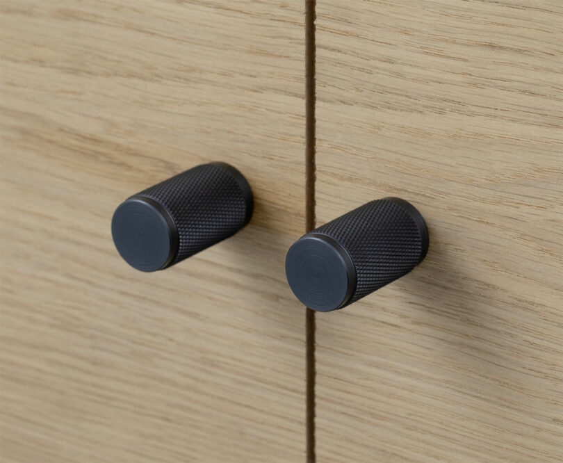angled closeup of knurled black cabinet pull knots