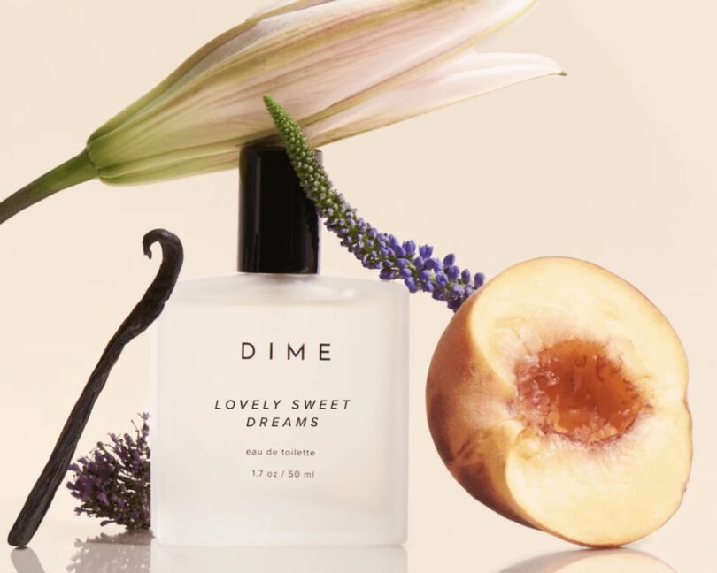 Dime Fragrance in Lovely Sweet Dreams, surrounded by notes found in the fragrance (peach, lavender, vanilla, and a flower)