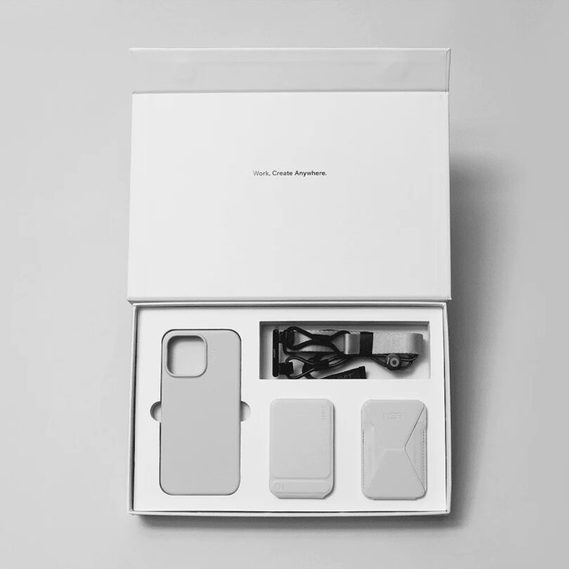 Moft Creator Kit in Misty Cove (light grey color) shown in a box -- includes a phone case, lanyard, phone stand, and snap-on stand + wallet combo.