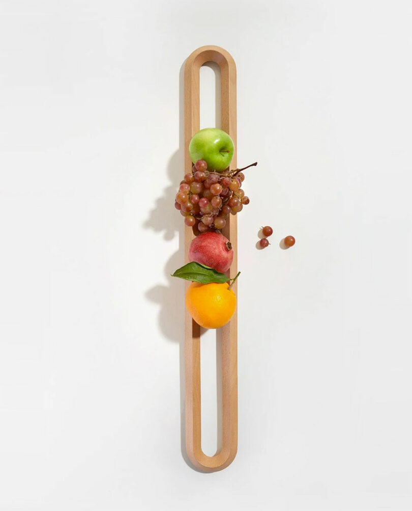 down shot of long wooden oval fruit bowl with fruit held inside