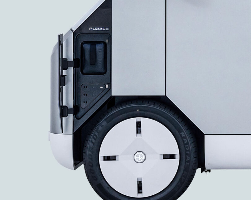 Detail of the Puzzle's power ports and outlets, alongside the vehicle's 15-inch wheels.