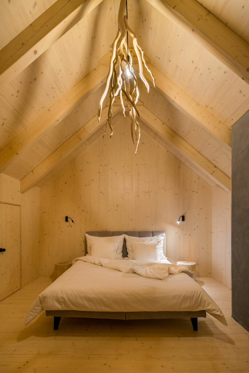minimalist bedroom with light wood walls and ceiling with branches hanging from ceiling