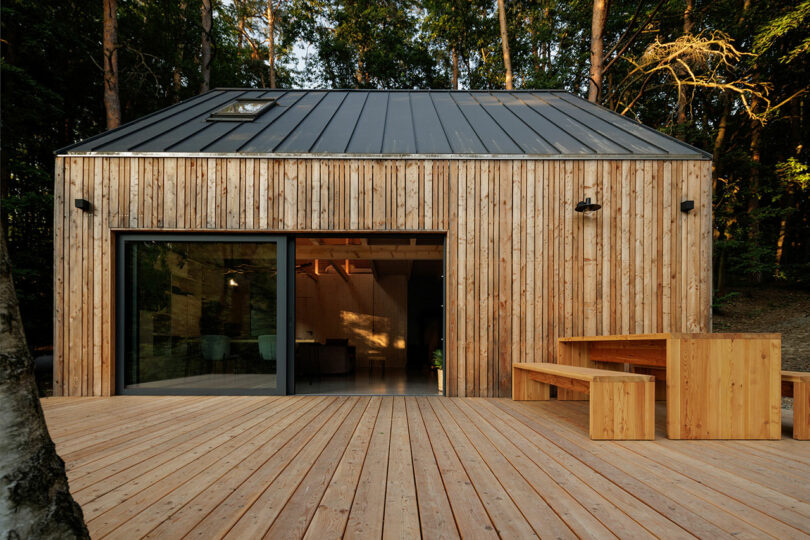 daytime exterior shot of modern wood cabin with a deck