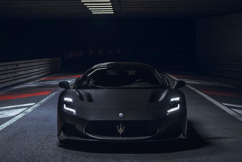 Front view of Maserati MC20 Notte Edition super sports car in matte and glossy black finish with white gold Trident logo in front air intake.