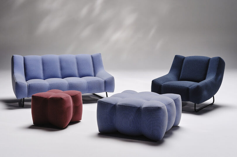 periwinkle blue sofa and matching pouf, maroon pouf, and dark blue chair