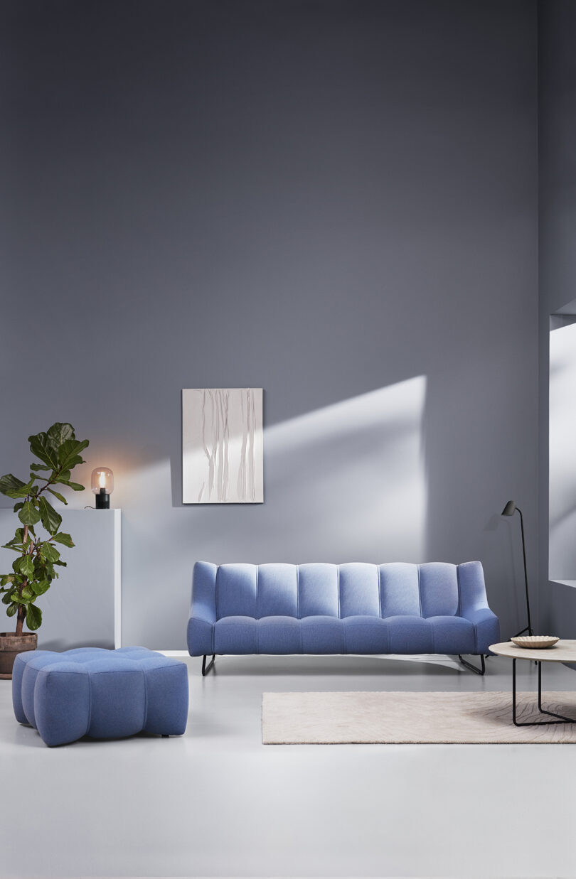 styled interior living space with periwinkle blue sofa and matching pouf