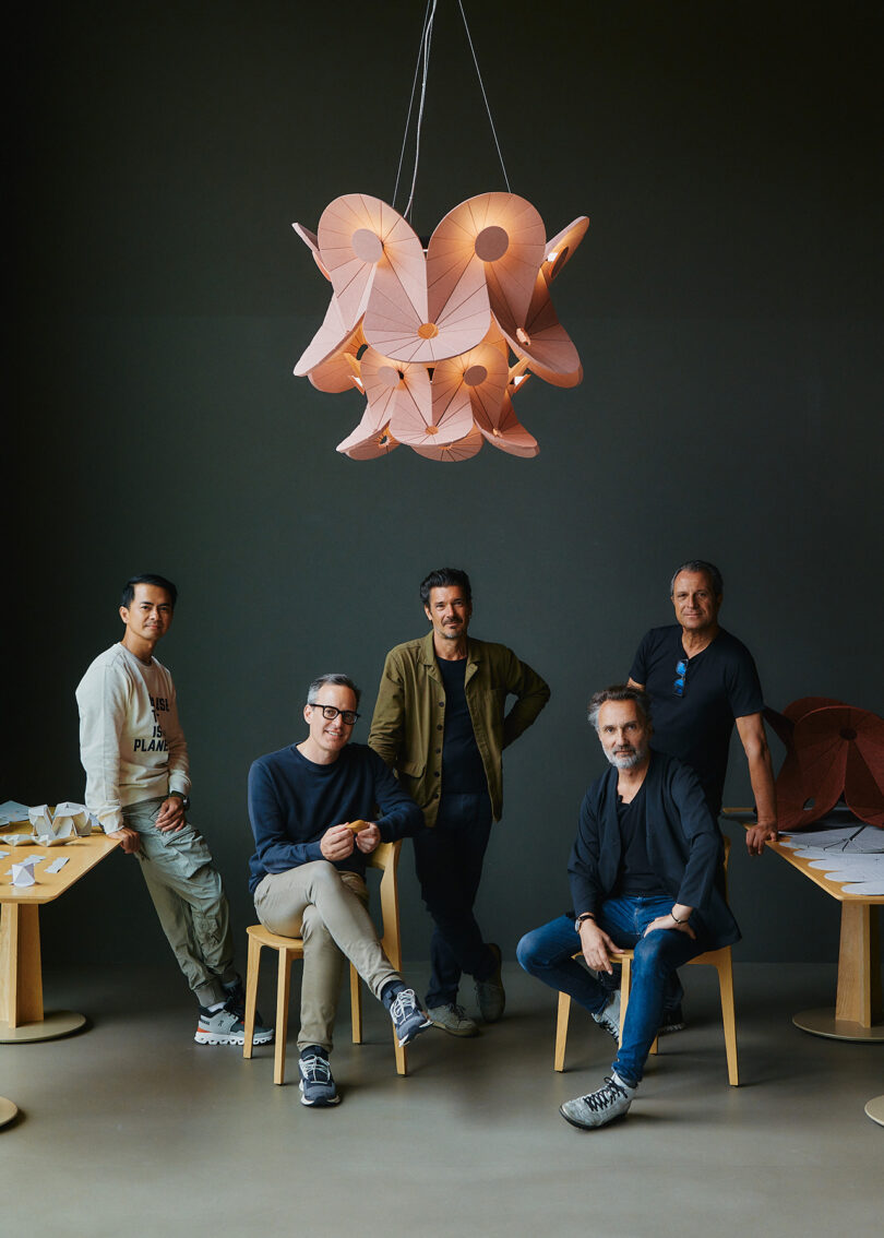 illuminated pink felt acoustic chandelier suspended over five men