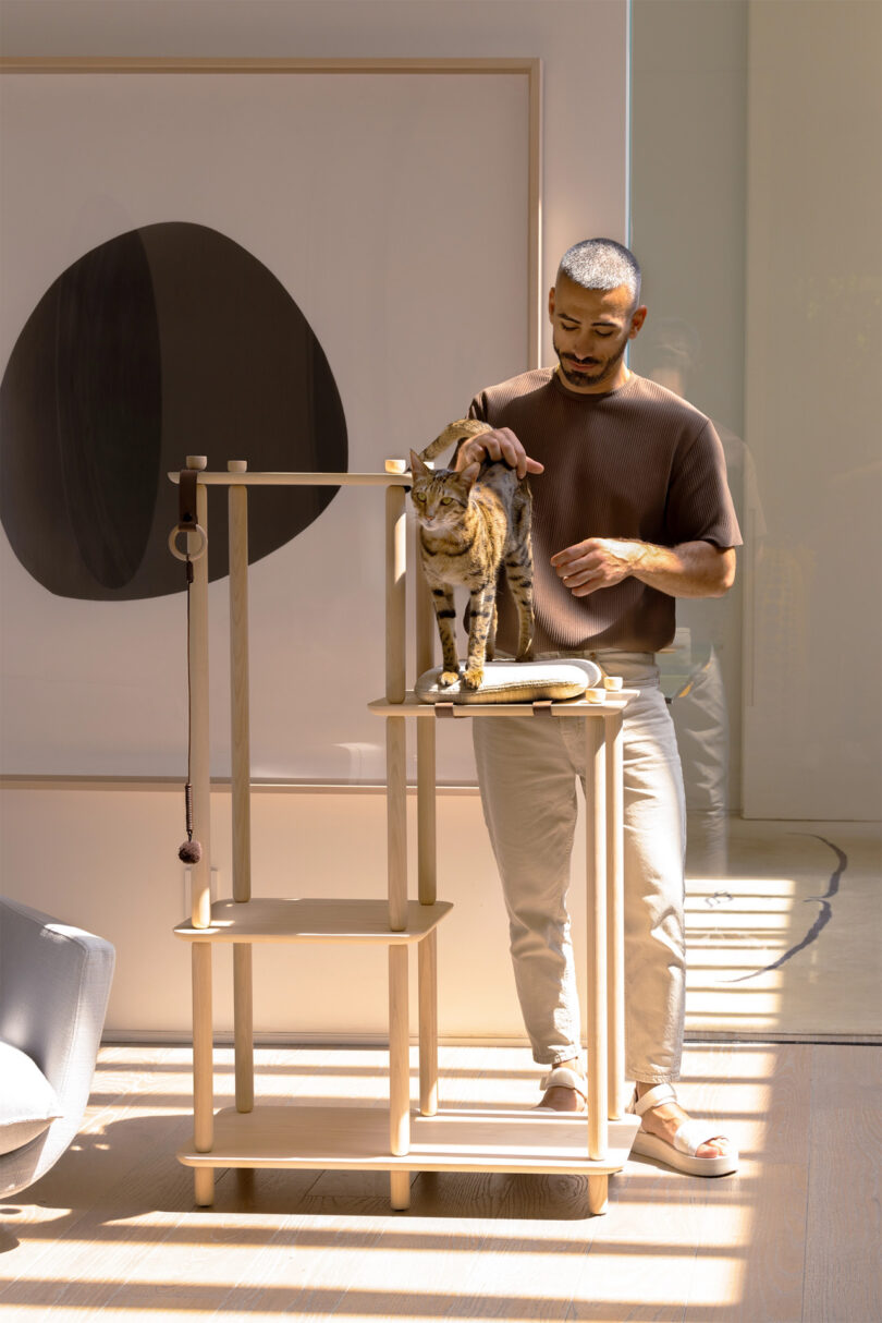 Vazken Karageozian standing alongside his Connect cat tree and one of his felines in a modern decor interior space.
