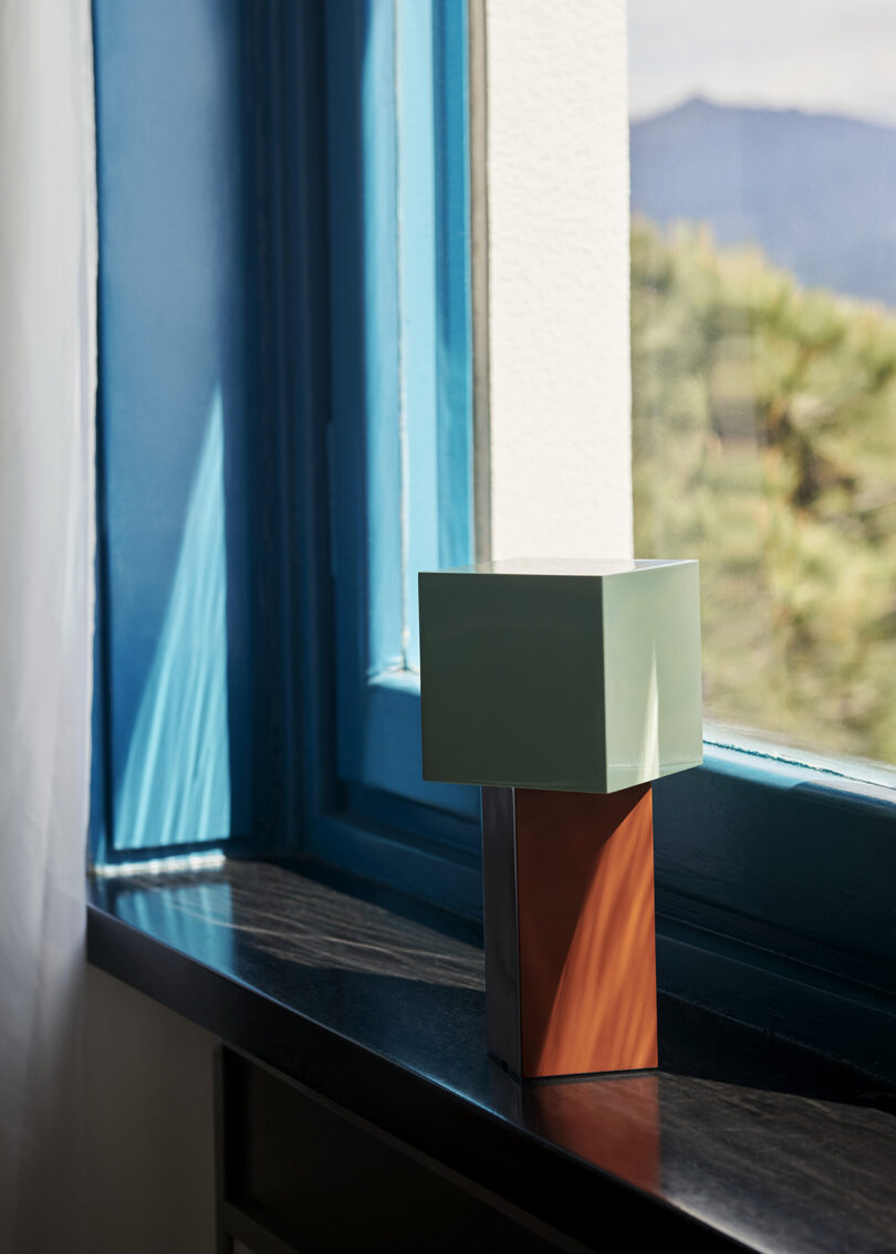 powder coated iron and mirror polished steel portable lamp on a windowsill