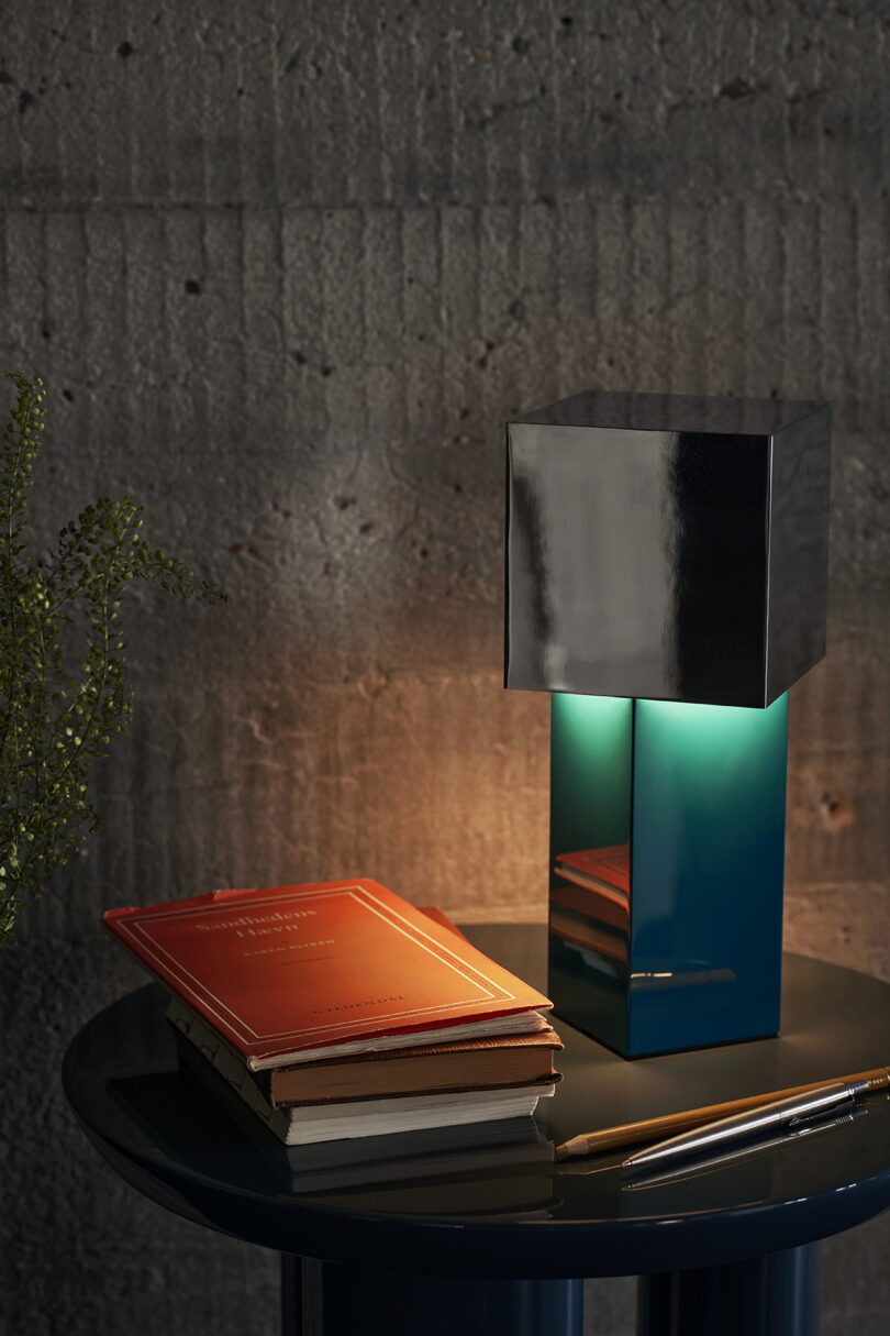 powder coated iron and mirror polished steel portable lamp on a table
