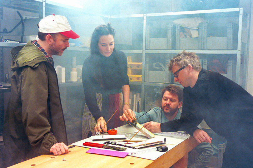 four people working around a work table strewn with tools