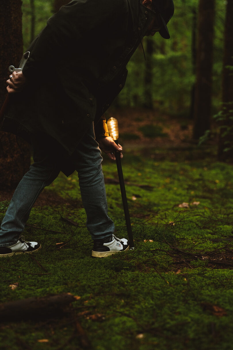 person using and outdoor torch in the forest