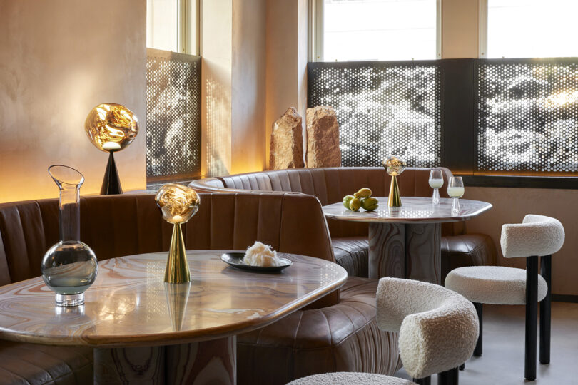 Side by side photos of Tom Dixon Melt portable rechargeable light in gold in a restaurant setting