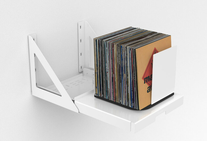 side view of white wall-mounted pull out shelf that holds and rotates stored vinyl records