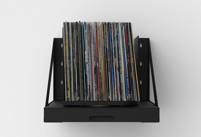 forward view black wall-mounted pull out shelf that holds and rotates stored vinyl records