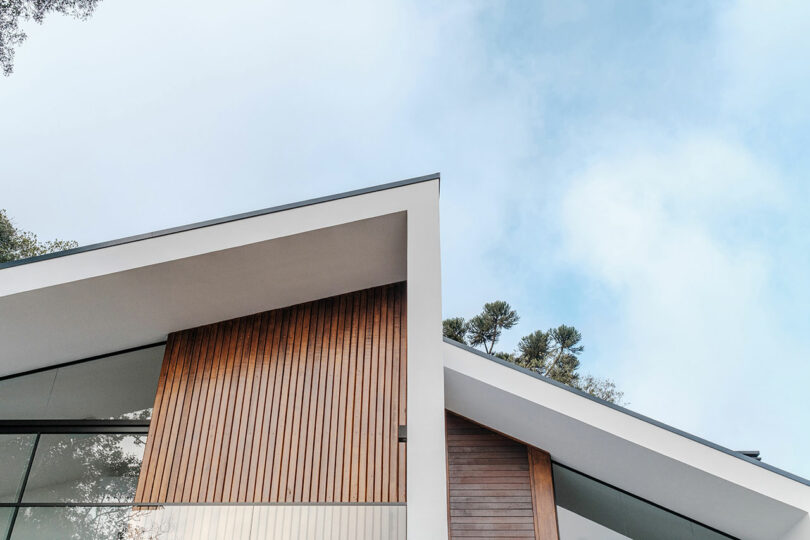 closeup up view of roof line of modern home with angular exterior with vertical wood slat cladding and gray details