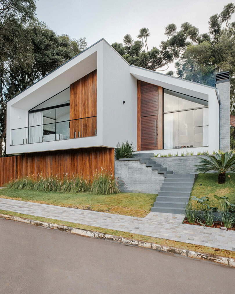 angled view of modern home with angular exterior with vertical wood slat cladding and gray details
