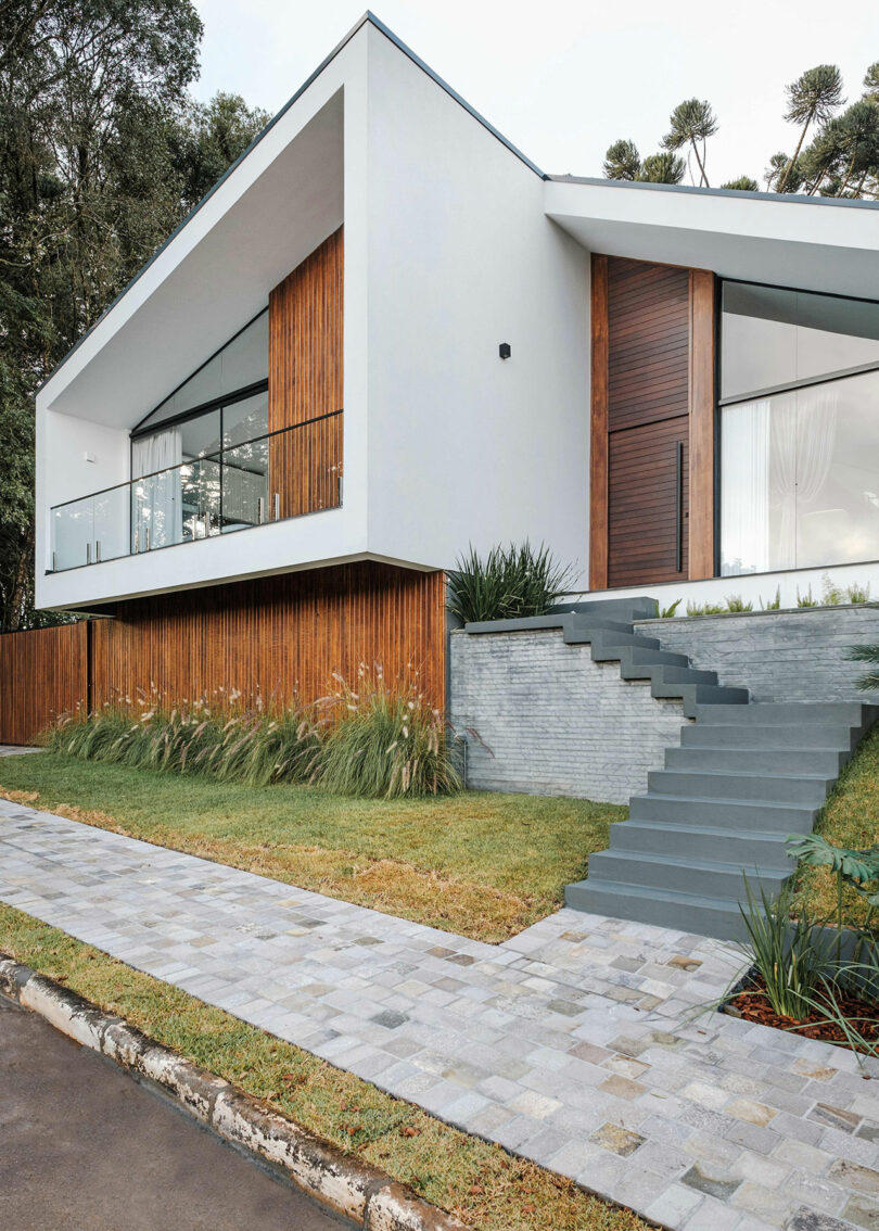 angled partial view of modern home with angular exterior with vertical wood slat cladding and gray details