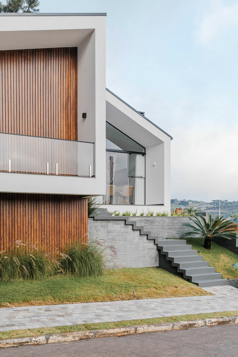 closeup angled view of modern home with angular exterior with vertical wood slat cladding and gray details