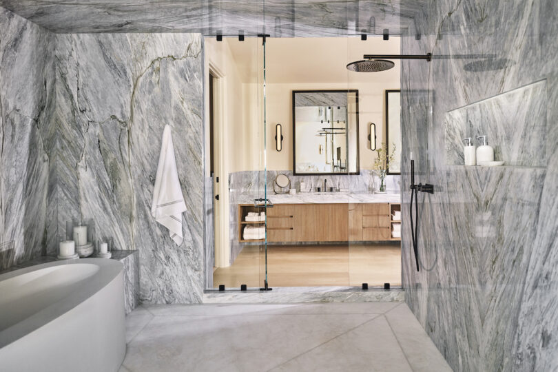 Modern primary bathroom with a stunning calcutta manhattan finish shower, complemented by minimalist decor and natural light