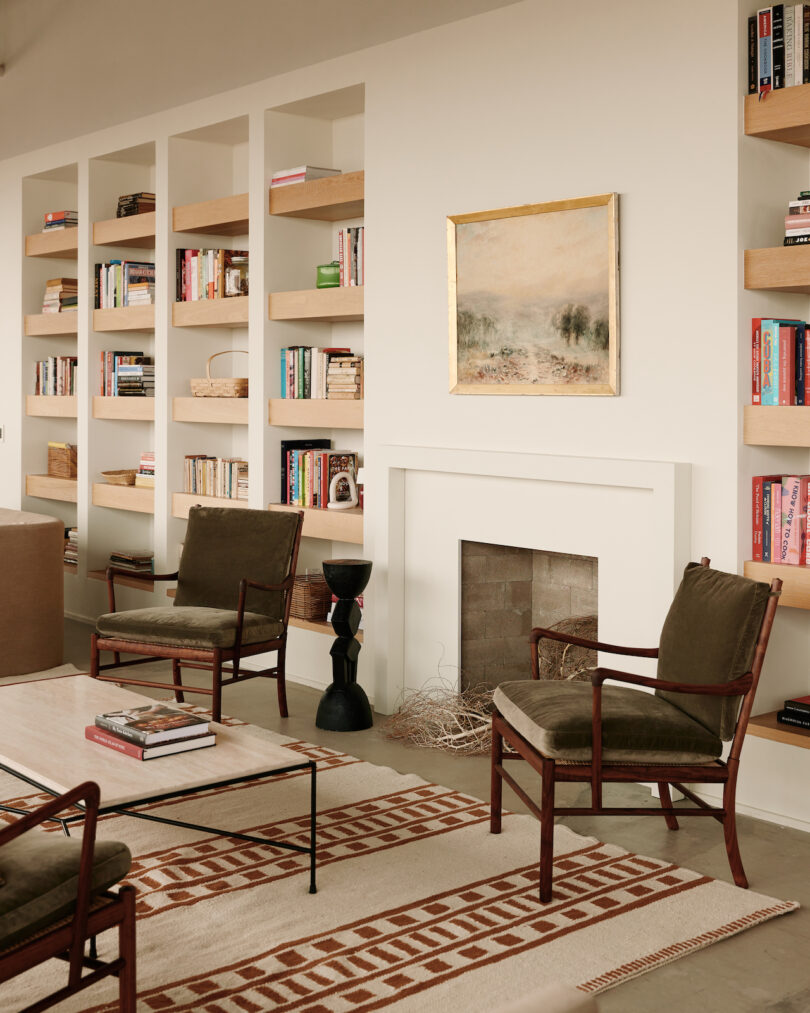 built-in shelving next to faux hearth flanked by chairs