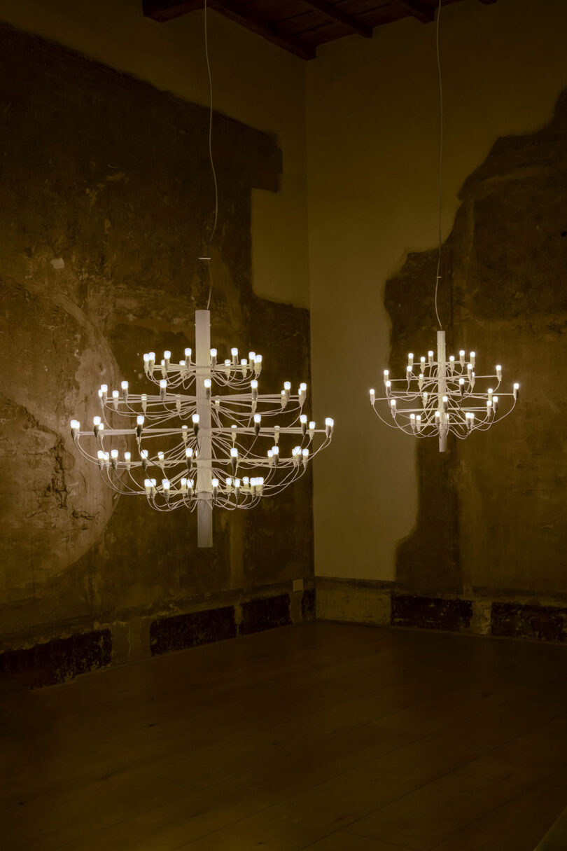 two minimalist chandeliers in an empty room