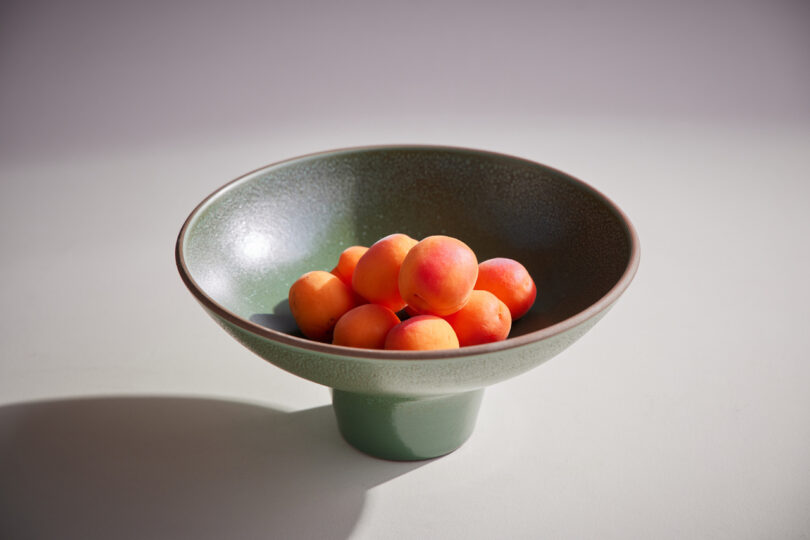 ceramic bowl holding orange fruit