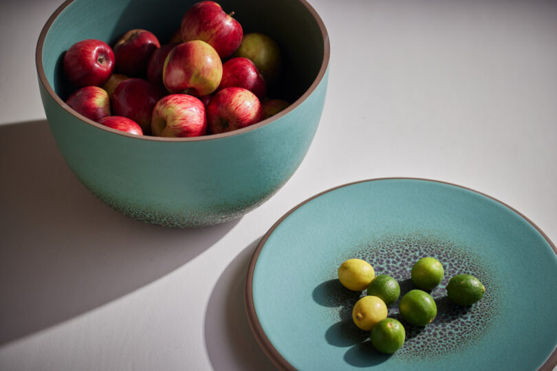 teal bowl and plate holding fruit