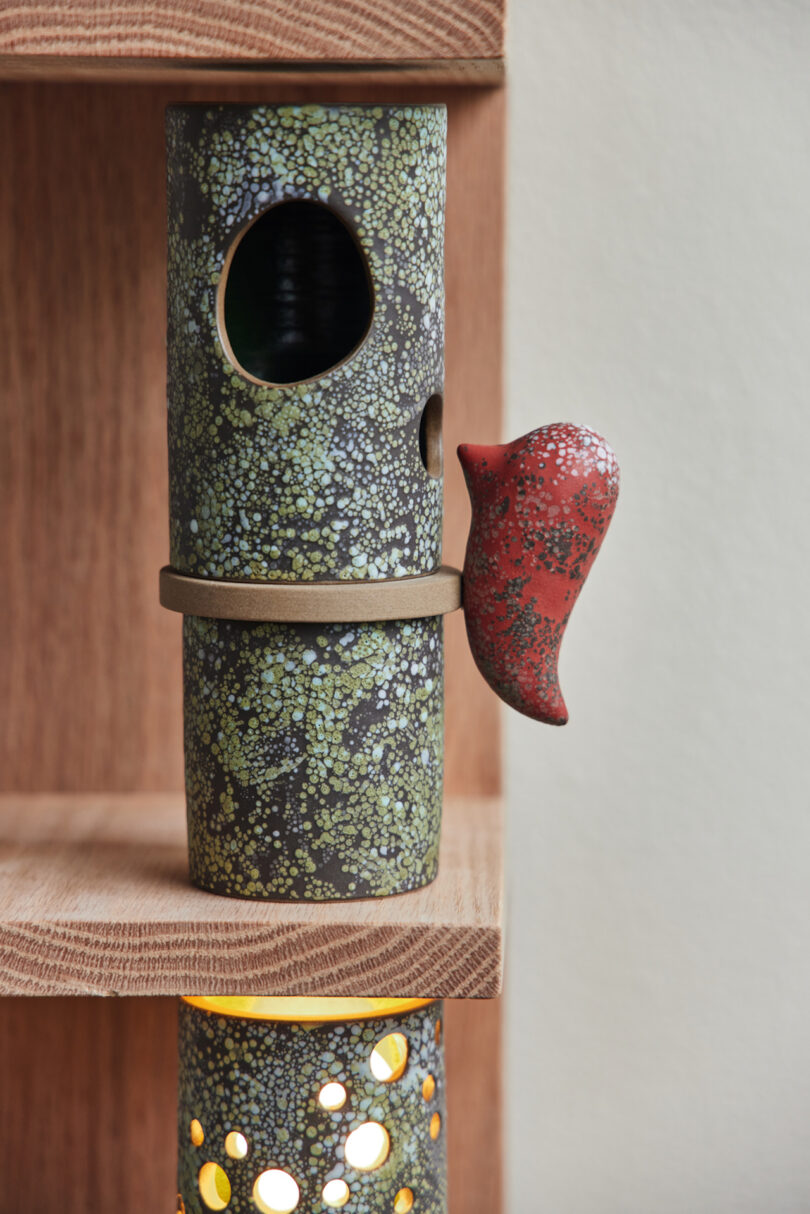 red ceramic bird on ceramic bird house