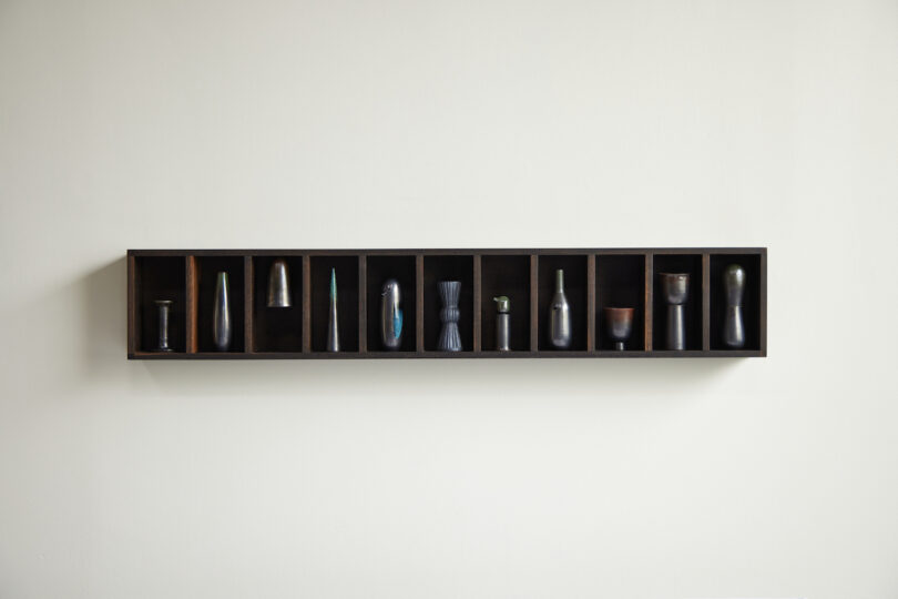ten ceramic objects inside wood shelf