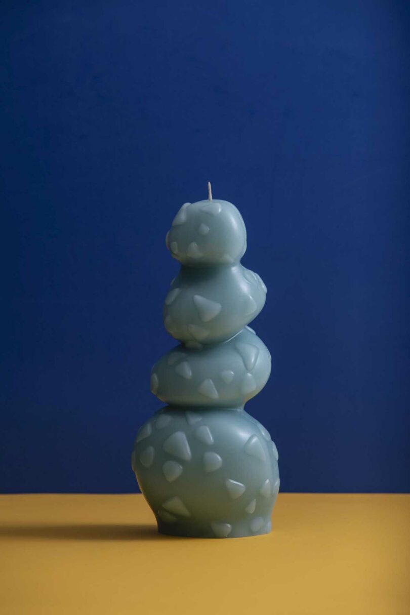 blue candle with four stacked forms