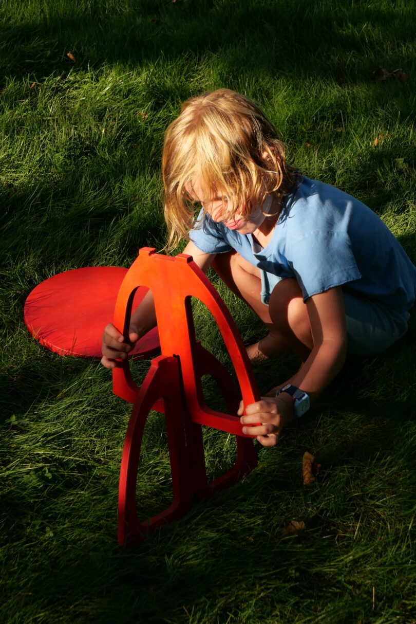 kid assembling a red chair