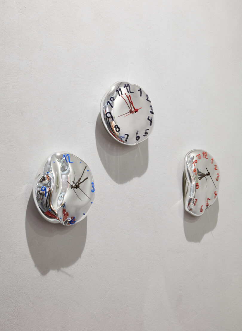 clock sculptures on white wall