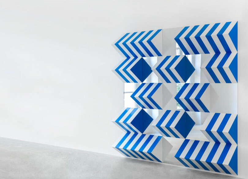 angled gallery view of blue and white striped prisms on wall