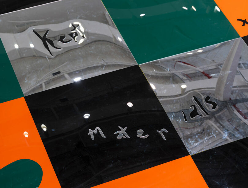 Detail of interactive orange, black, dark green, and silver metallic dance floor tiles.