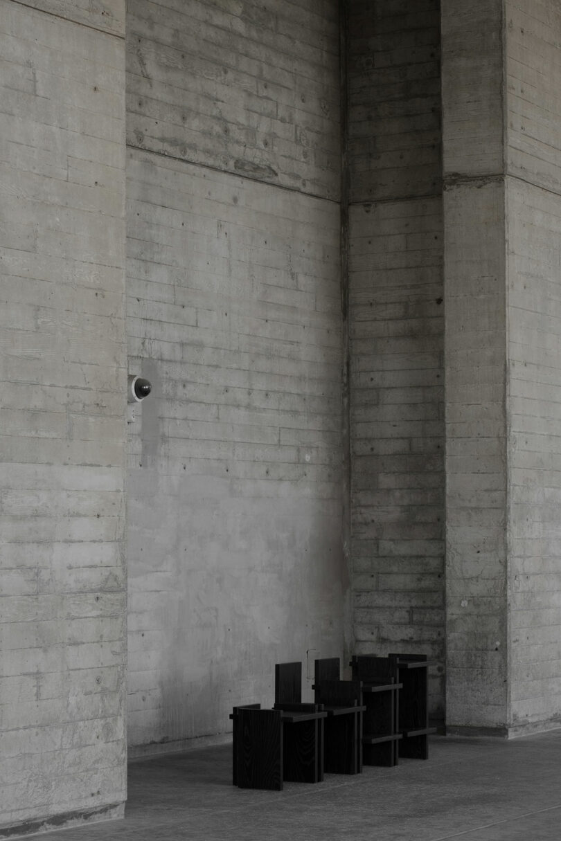Series of black chairs in concrete alcove